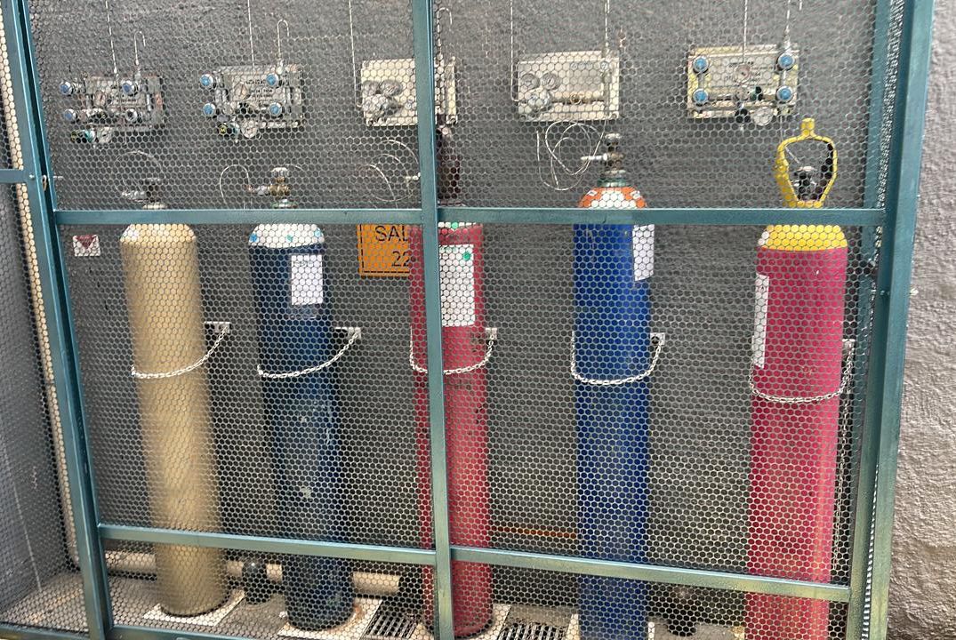 Central de gases especiais com cilindros identificados em gaiola de proteção